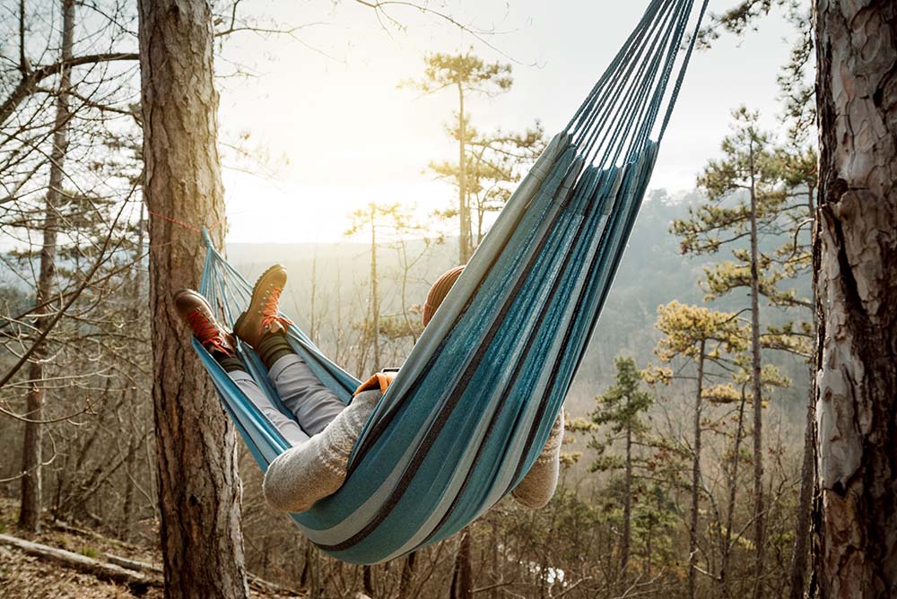 Man lying in hammock outside in nature